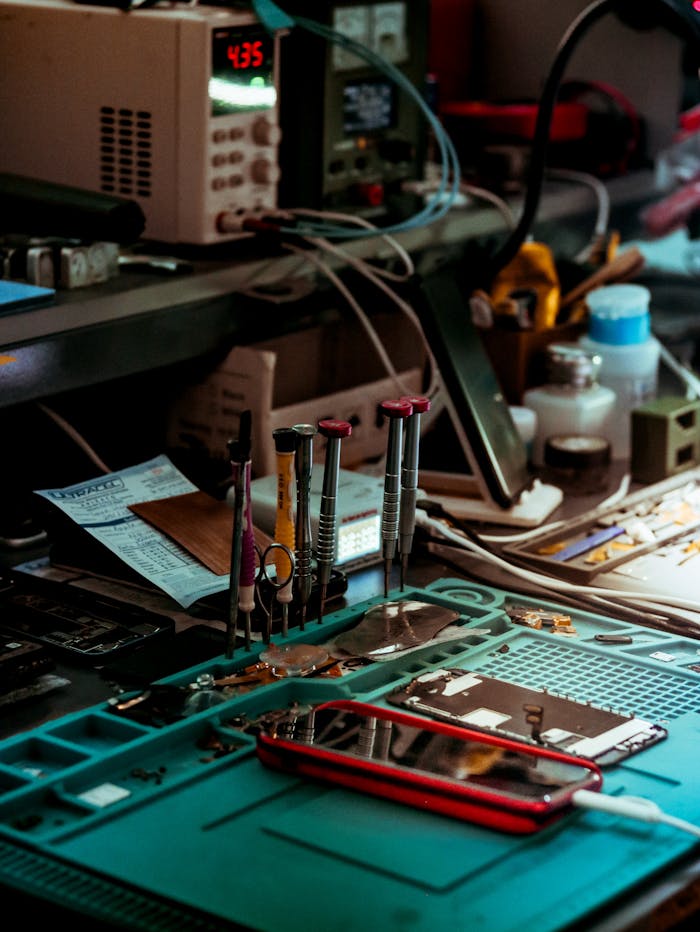 services-01 Detailed view of a tech repair workspace with tools and electronics parts.