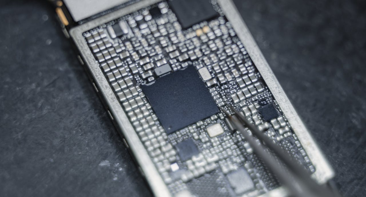 ours-journey Detailed view of a circuit board being worked on with a precision tool, highlighting electronic components.